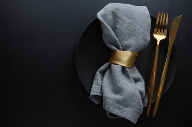 gold cutlery on a black plate